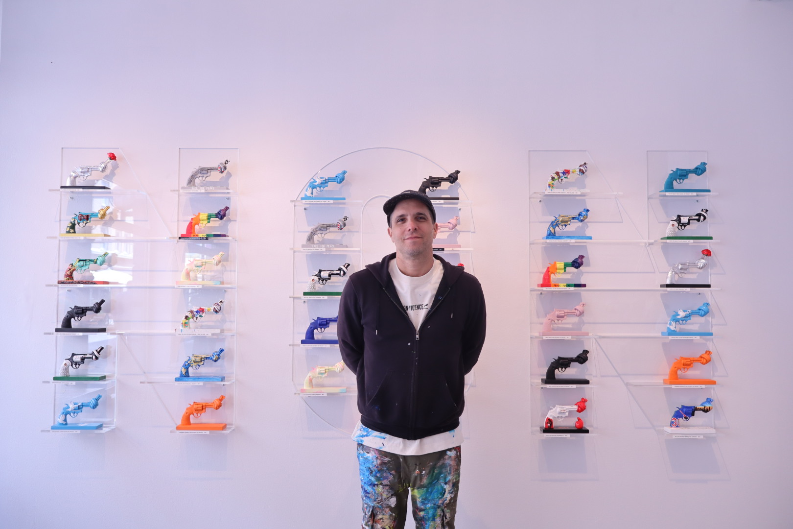 Non-Violence ambassador Shai Dahan with different knotted gun sculptures.